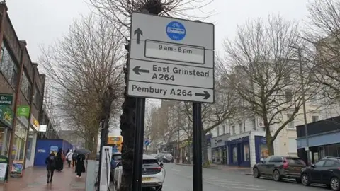 Hamish Mureddu-Reid/BBC A street sign in Tunbridge Wells with a blue circular notice.