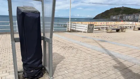 Aberystwyth promenade with a parking machine that is covered in a black bag to show it isn't working/in use.