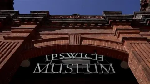 exterior and sign of Ipswich Museum showing red brick Victorian building and lettering
