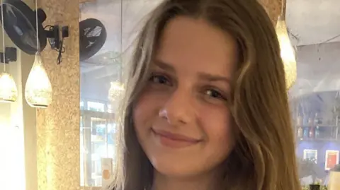 Family photo A photo of Eleanor Hague. She has long light brown hair and is smiling