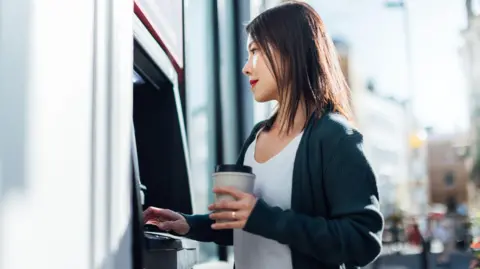 Getty Images Woman at a cash machine