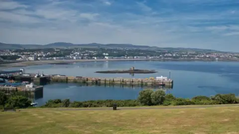 MANX SCENES A view of Douglas from Douglas Head - you can see the large bay, there is the tower of refuge in the sea, and hills in the background.