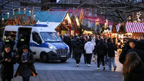 Reuters A police car secures an entrance of the Christmas market on the Breitscheidplatz, after a car rammed into a crowd of people at the Magdeburg Christmas market, in Berlin, Germany December 21, 2024