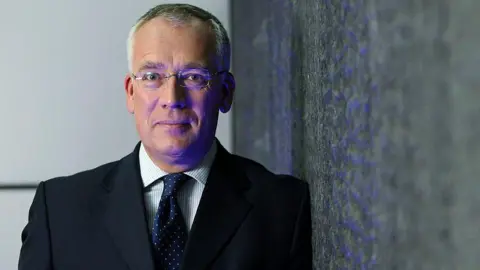 Chris Ratcliffe/Bloomberg via Getty Images Richard Meddings stands facing the camera for a headshot benignant   photograph