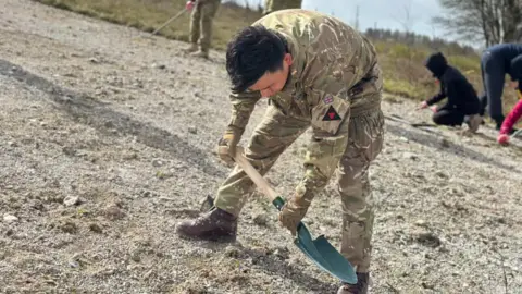 Crown A soldier using a shovel on a chalky surface