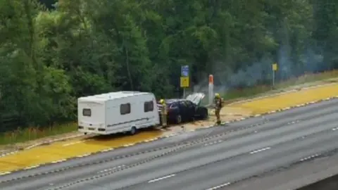Firefighter tackling a car fire on the M1