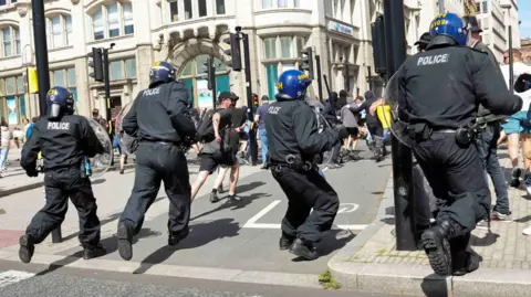 Reuters Riot officers charge at protesters on the Pier Head