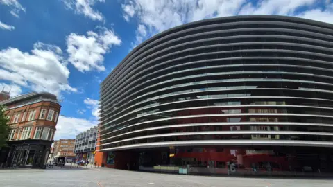 Supplied A large curved building with metal cladding