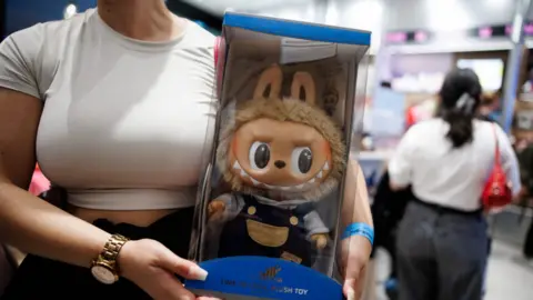 EPA A customer holds a box with a toy figure in the first Pop Mart store selling Labubu toys in Berlin