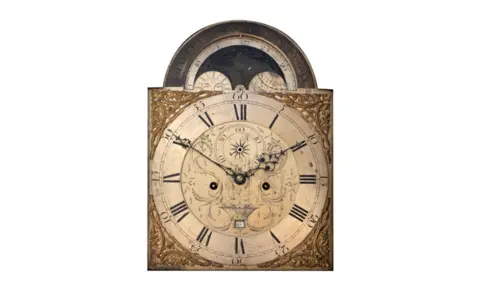 Scott Media A clock face with ornate gold decorative corners and 