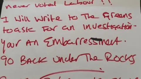 A letter written in red pen, received by former Labour Party member Kevin Robinson-Hale. In a mixture of capital and lower case letters, the visible section says ".... never vote Labour. I will write to the Greens to ask for an investigation. You're an embarrassment. Go back under the rocks." 
