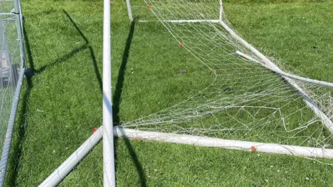 Lee Bailey A close-up picture of a goal broken on grass