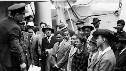 PA Media File photo dated 22/06/48 of Jamaican immigrants welcomed by RAF officials from the Colonial Office after the ex-troopship HMT Empire Windrush landed them at Tilbury
