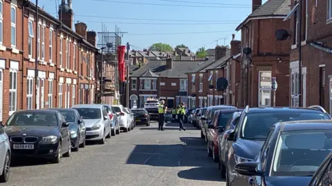 View looking down street with police officers conducting inquiries