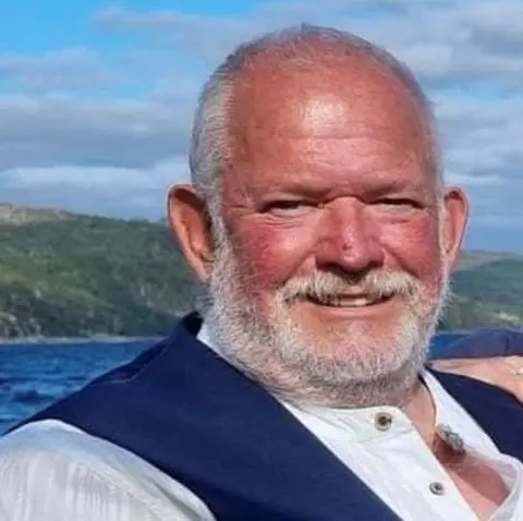 Robin Pettigrew Robin Pettigrew, a bald man with a beard. He is smiling and is wearing a white shirt and blue waistcoat