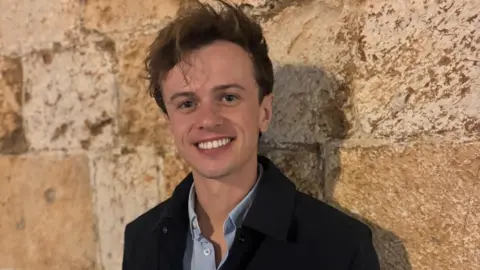 Llŷr Wyn Williams A man smiles at the camera 