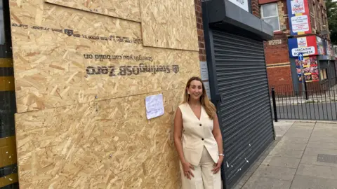 Alex McCormick standing outside the boarded-up library on County Road