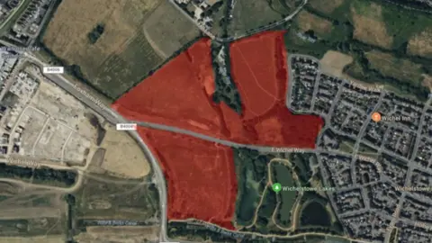 Swindon Borough Council Google Maps image, aerial shot, of a main M4 road and an area in red showing where planning could take place