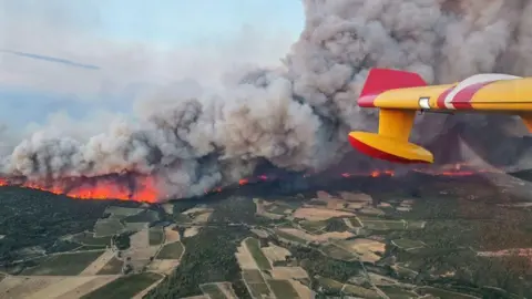 Préfet de l'Aude Uma parede de fogo vista de uma aeronave queima através da colcha de retalhos verdes dos campos do sul da França.