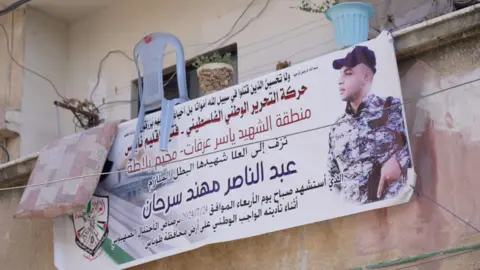 A poster hanging on the balcony shows Arabic text and a picture of the murdered young man