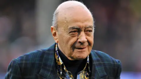 PA Media Mohamed Al Fayed head and shoulders shot wearing tartan suit and paisley pattern shirt