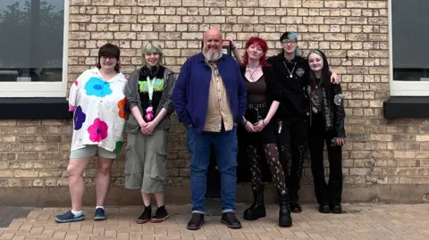 Six people standing outside The Warren Youth Project in Hull. In the centre of the picture is chief executive JJ Tatten.