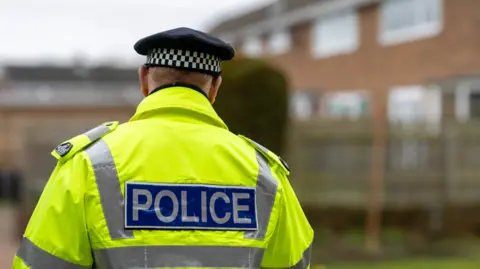 Getty Images The back of a police officer wearing a high vis jacket.