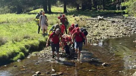 Glossop Mountain Rescue Team taking injured walker to safety