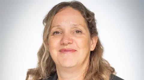 A picture of Wendy Wilson. She has blonde hair and is wearing a black jacket.