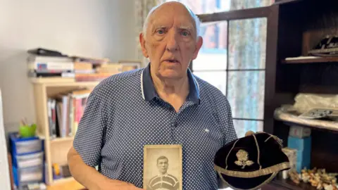 BBC Brian Penny holding a picture of his grandfather