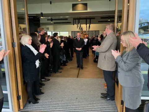 People pictured paying their tributes at Mr Perkins' funeral