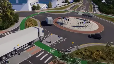 Hertfordshire County Council/YouTube A long white lorry approaches the roundabout, which has two cars navigating it. The roundabout is surrounded by a green cycle land and various pedestrian crossings.