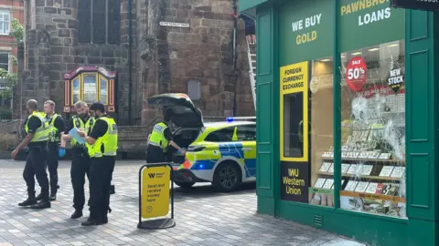 Police near smashed windows of Ramsdens Pawnbrokers