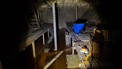 ArcelorMittal Kent Wire A torch lights up a dark room. The room appears flooded and very dilapidated.