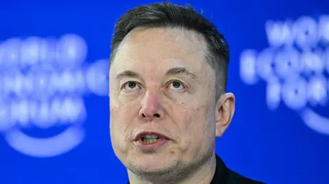 A head shot of CEO of SpaceX and Tesla, South African-Canadian-US businessman Elon Musk, with a blue background