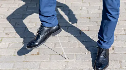 A man getting chewing gum stuck to the sole of his shoes.