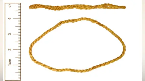 The Portable Antiquities Scheme Two views of a gold loop, made from three strands of beaded wire that have been twisted together. The top view shows it from the side and the bottom view shows the loop which is a flattened oval.