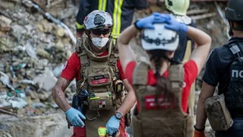 Getty Images Reddings- en strijdkrachten ruimen het puin op van het verwoeste gebouw van het Ohmatdyt Kinderziekenhuis na een raketaanval in de Oekraïense hoofdstad Kiev op 8 juli 2024.