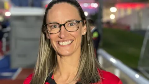 ERICA BELLHOUSE Erica Bellhouse, who has long brown hair and glasses, and is wearing an Isle of Man Commonwealth Games branded top from Birmingham in 2022.