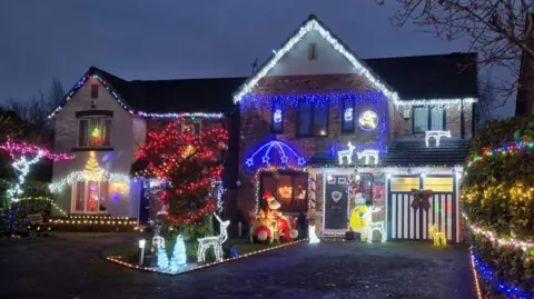 Peter Marr Two detached houses covered in Christmas lights.