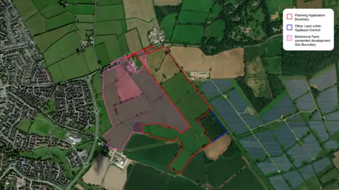 Gleeson Land Green fields and houses seen from above. It is an aerial satellite image. There are houses to the left of the image, and fields and trees to the right.