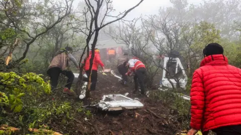 Iranian rescue teams recover the bodies from the crash site of the Iranian presidential helicopter in the dense forest of Dizmar between the cities of Varzaqan and Jolfa in East Azerbaijan province, Iran on May 20, 2024