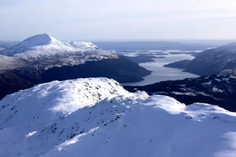 Grant McLean A snow-covered landscape of mountains with Loch Lomond through the centre of the image.