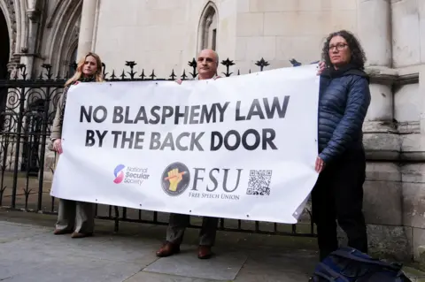 PA Media Hamit Coskun (centre) with supporters at the Royal Courts Of Justice, London after a hearing in the Crown Prosecution Service appeal against the overturning of his conviction for burning a Quran