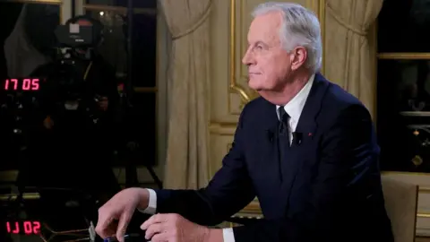 France's Prime Minister Michel Barnier delivers remarks during a televised interview broadcast on the evening news on French TV channels, at Hotel Matignon in Paris, France, on 3 December 2024