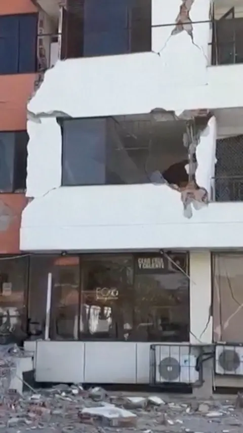 A collapsing building facade after it was struck by an earthquake.
