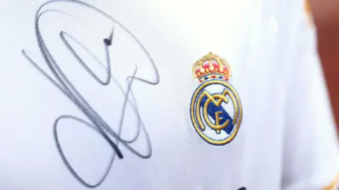 A close up image of a Real Madrid shirt signed by Kylian Mbappe