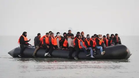 People wearing bright orange life jackets in an inflatable life jacket floating on the water