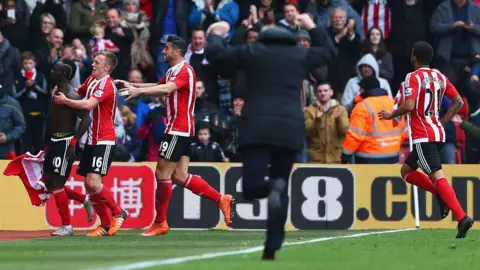 Getty Images Ronald Koeman running down the touchline to celebrate with his Southampton players who are bundled together by the fans who are stood in the stands