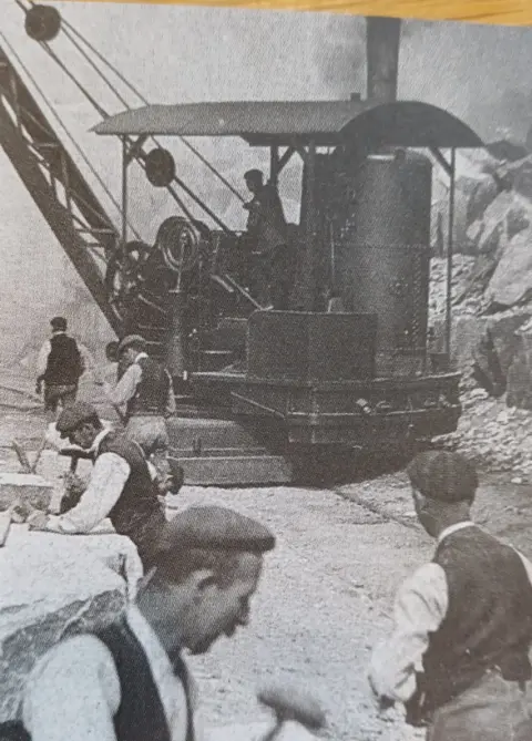 Severn Trent In the foreground, workers can be seen holding tools and working, with a crane being operated in the background